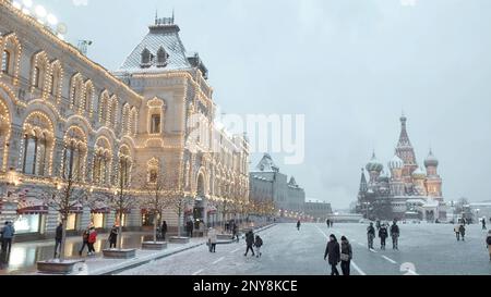 Bellissima piazza della città in una giornata innevata prima delle vacanze di Capodanno. Azione. Persone che camminano di fronte a edifici storici e templi Foto Stock