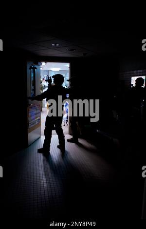 STAZIONE AEREA DI GUARDIA COSTIERA KODIAK, ALASKA - STATI UNITI I membri del Coast Guardsmen con il Maritime Security Response Team West sgomentano un edificio il 10 gennaio 2023, durante l'allenamento di combattimento nei pressi della Coast Guard Air Station Kodiak, Alaska. MSRT West è in grado di interdire, imbarcarsi e verificare le minacce, nonché di intraprendere operazioni offensive contro una minaccia ostile. Foto Stock