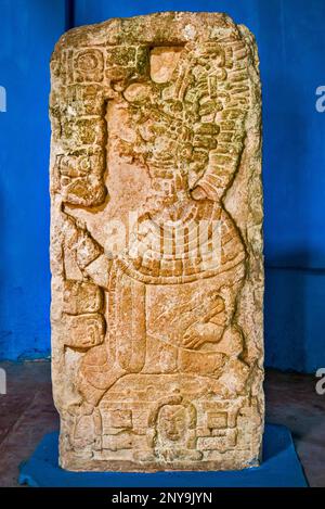 Stela di pietra esposta sotto una palapa al sito archeologico di Edzna, penisola dello Yucatan, stato Campeche, Messico Foto Stock