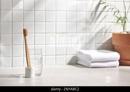 Vari oggetti su uno sfondo piastrellato bianco con luce solare calda che splende attraverso Foto Stock