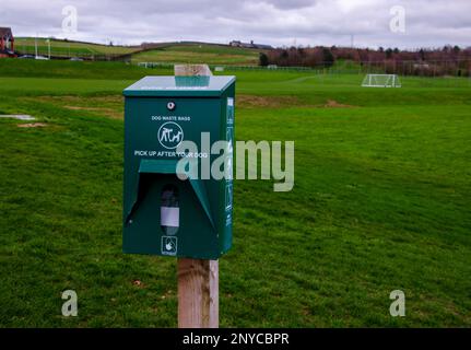 Stazione di distribuzione del sacchetto del poo del cane vicino ai campi di gioco Foto Stock