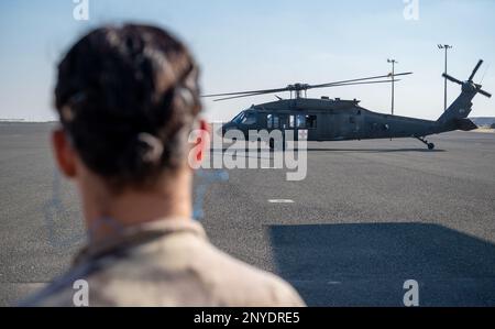 Una medica dell'esercito canadese guarda come Stati Uniti L'elicottero Army UH-60 Blackhawk atterra nelle vicinanze alla base aerea di Ali al Salem, Kuwait, 20 gennaio 2023. Il 405th° Squadrone di evacuazione Aeromedica Expeditionary, il 386th° Squadrone medico Expeditionary e i membri degli Stati Uniti Le forze dell'esercito e della coalizione si sono unite per una simulazione reale sul carico e lo scarico dei pazienti da un elicottero UH-60 Blackhawk. La formazione ricevuta aiuterà a salvare vite sul campo, consentendo la rapida evacuazione dei soldati in strutture mediche di alto livello. Foto Stock