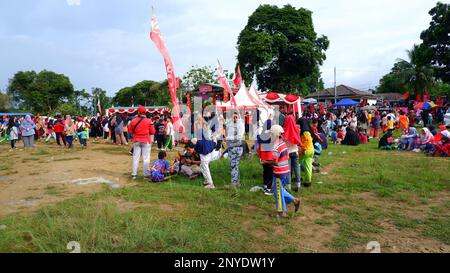 I residenti si sono riuniti sul campo ad Un evento di festa della gente nella città di Muntok Foto Stock