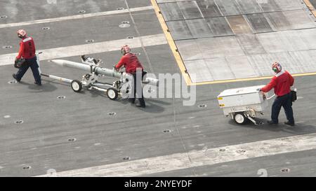 230117-N-NX635-1064 SOUTH CHINA SEA (17 GENNAIO 2023) USA I marinai della Marina trasportano l'ordnance sul ponte di volo a bordo della portaerei USS Nimitz (CVN 68). Nimitz è presente negli Stati Uniti nel 7th Fleet e svolge operazioni di routine. 7th Fleet è la flotta statunitense La flotta numerata più grande della Marina e interagisce e opera regolarmente con alleati e partner per preservare una regione indomorosa e libera. Foto Stock