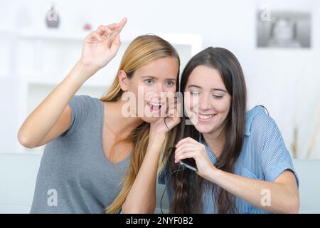 Due ragazze che ascoltano musica e cantano Foto Stock