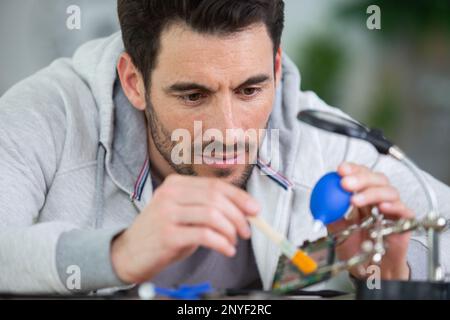 uomo che pulisce l'obiettivo della fotocamera Foto Stock