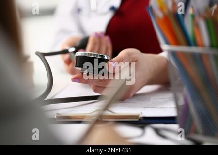 Il medico controlla la pressione sanguigna del paziente in clinica Foto Stock