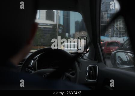 Conducente Uber su strada con GPS del telefono Foto Stock