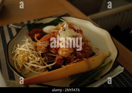 Un grande piatto di pad thai con una bella presentazione Foto Stock