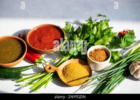 Cucina tradizionale georgiana con spezie, salse su un tavolo bianco Foto Stock