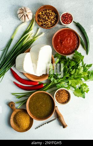 Cucina tradizionale georgiana con spezie, salse su un tavolo di cemento Foto Stock