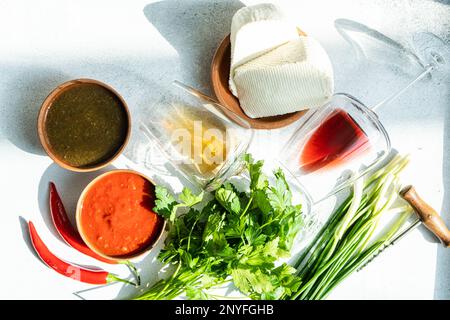 Cucina tradizionale georgiana con spezie, salse e vini su un tavolo di cemento Foto Stock