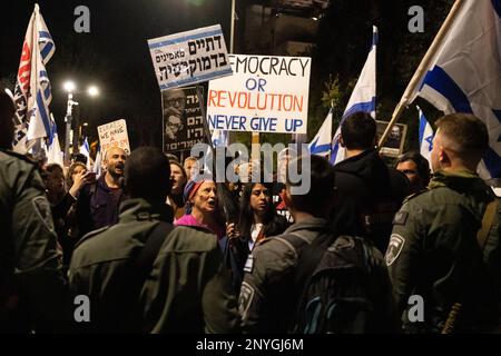 Israele. 01st Mar, 2023. I manifestanti contro la riforma hanno dei segnali e delle bandiere israeliane davanti a una polizia di frontiera cruda a Gerusalemme, i segnali recitano: “Le persone religiose credono nella democrazia”, “Israele ha un problema”, “democrazia o rivoluzione, non arrendersi mai” e “cosa avrebbero detto?” Con le immagini delle figure di destra conosciute Zeév Jabotinsky e Menachem cominciano. I manifestanti israeliani contro la riforma legale si sono alleati in tutto il paese per distrarre l'ordine pubblico. 38 manifestanti sono stati arrestati durante le manifestazioni. Mar 1th 2023. (Foto di Matan Golan/Sipa USA). Credit: Sipa USA/Alamy Live News Foto Stock