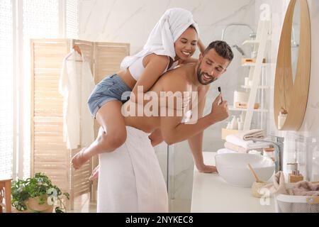 Una coppia adorabile che si diverte mentre si lavano i denti in bagno Foto Stock