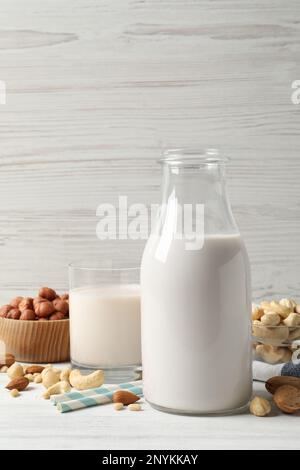 Diversi tipi di latte di noce su un tavolo di legno bianco Foto Stock