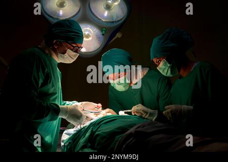 Team medici sala operatoria vestiti uniformi verdi salvando vite criticamente paziente sottoposto a chirurgia cardiaca per i pazienti di cuore vi standardizzato surg Foto Stock