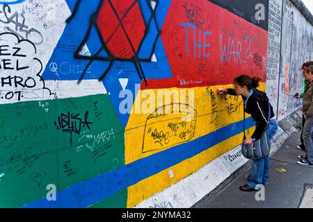 La East Side Gallery.La scrittura mensages nella parete su un disegno di stelle gli ebrei e la bandiera tedesca.Berlino. Germania Foto Stock