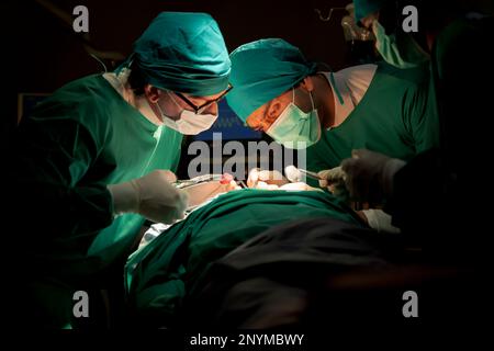 Team medici sala operatoria vestiti uniformi verdi salvando vite criticamente paziente sottoposto a chirurgia cardiaca per i pazienti di cuore vi standardizzato surg Foto Stock