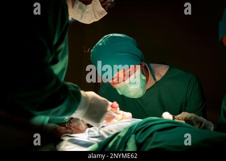 Team medici sala operatoria vestiti uniformi verdi salvando vite criticamente paziente sottoposto a chirurgia cardiaca per i pazienti di cuore vi standardizzato surg Foto Stock