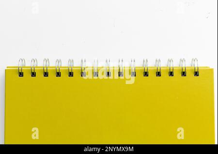 Primo piano di un notebook giallo con pagine a scacchi. Notebook a spirale isolato Foto Stock