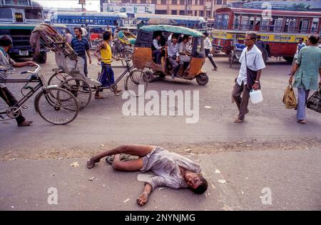 India, Calcutta o Kolkata, senzatetto e psicologicamente confuso, gli uomini malati sono impotenti per strada. Gli astanti camminano su non affected. Foto Stock