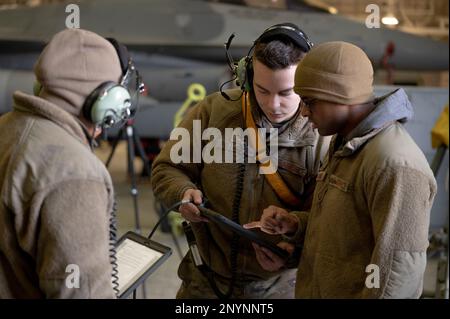 STATI UNITI Air Force Airmen assegnato al 25th Fighter Generation Squadron ha letto su una lista di controllo di ispezione di fase presso Osan Air base, Repubblica di Corea, 12 gennaio 2023. L'hangar di fase riunisce più negozi per collaborare ed è un'area dedicata alla manutenzione approfondita degli aerei. Foto Stock