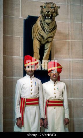 India, Jodhpur. I servi dell'hotel si trovano di fronte alla tigre indiana imbottita. Foto Stock