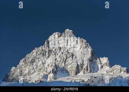 Aiguille de l’Encrenaz in primo piano coperto dalla recente nevicata all’alba a metà inverno a Chamonix, Francia Foto Stock