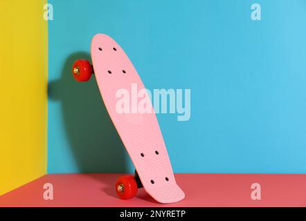 Skateboard rosa su sfondo colorato. Spazio per il testo Foto Stock