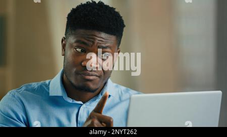 Arrabbiato uomo infastidito african businessman boss parlare in video conferenza utilizzare computer litigare conflitto contestare cattivo servizio parlando lontano grido Foto Stock