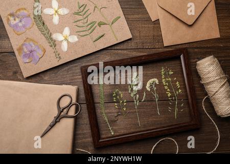 Composizione piatta con fiori secchi e piante su tavola di legno Foto Stock