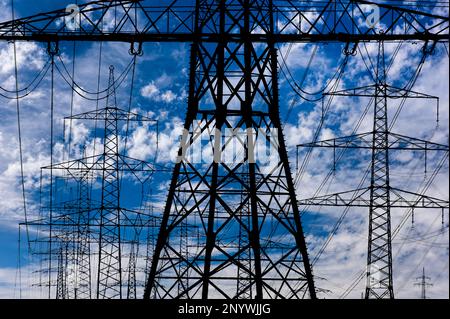 l'alta tensione di energia e l'elettricità pilone contro il cielo Foto Stock