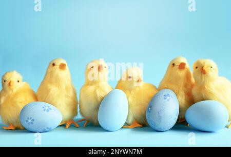 Banner. Uova blu e pulcini gialli su sfondo blu. Cartolina di Pasqua con una copia del luogo per il testo Foto Stock