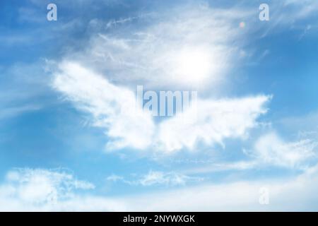 Silhouette di ali d'angelo fatta di nuvole nel cielo blu Foto Stock