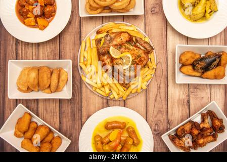 Set di tipici piatti di tapas spagnolo con ricette note, pollo arrosto la domenica, crocchette, empanadillas, cozze tigres, chistorra con patate Foto Stock