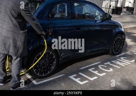 Ricarica elettrica FIAT 500 in una stazione di ricarica stradale nel centro di Londra, Inghilterra, Regno Unito Foto Stock