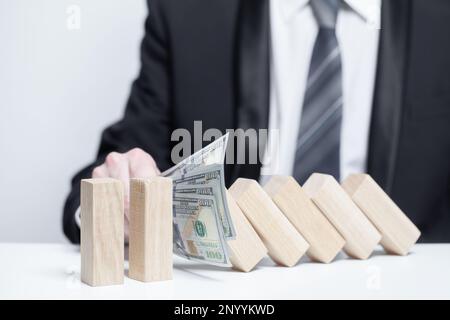 Blocchi di legno sotto i soldi noi protezione di dollari, domino, concetto di proprietà di sicurezza di assicurazione Foto Stock