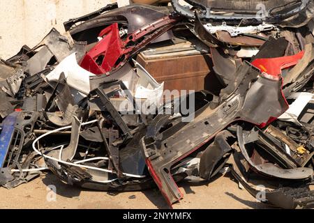 paraurti rotti e parti di automobili sulla strada come spazzatura Foto Stock