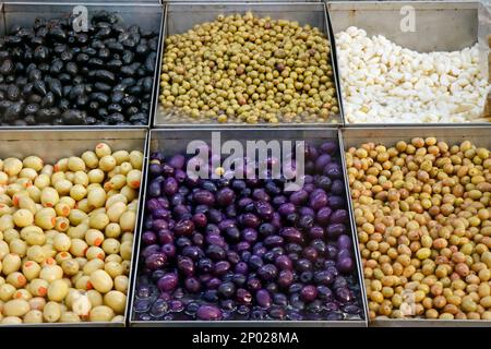 varietà di olive marinate e sottaceto in una bancarella per la vendita Foto Stock