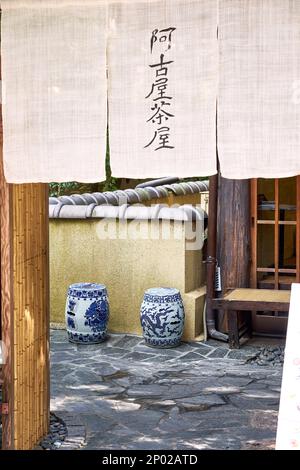 Porta di una casa giapponese con stoffa appesa e vasi da pavimento decorati in giapponese a Kyoto, Giappone Foto Stock