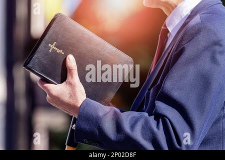 Pastore con una Bibbia in mano durante un sermone il predicatore consegna un discorso Foto Stock