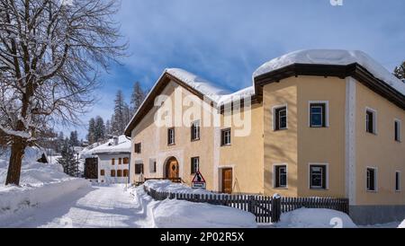 Cinuos-Chel, Svizzera - 3 febbraio 2022: Villaggio innevato di Cinuos Chel e tipiche case storiche in Engadina, Graubunden, SW Foto Stock