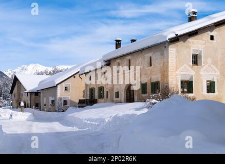 Cinuos-Chel, Svizzera - 3 febbraio 2022: Villaggio innevato di Cinuos Chel e tipiche case storiche in Engadina, Graubunden, SW Foto Stock