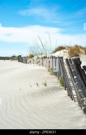 estate vista spiaggia in camargue con un vecchio e arrugginito recinto sepolto nella sabbia Foto Stock