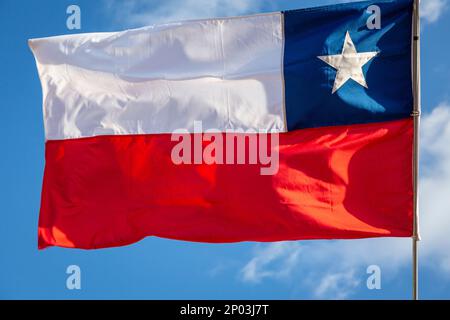 Chile National Flag che sventolava in pole contro il cielo azzurro soleggiato, Sud America Foto Stock