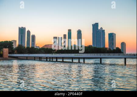 Tramonto Paesaggio dei grattacieli di Sharjah sopra l'acqua negli Emirati Arabi Uniti Foto Stock