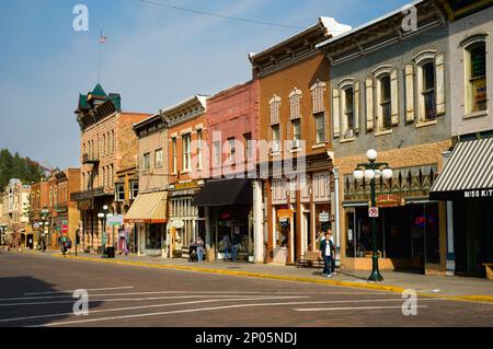 Negozi, saloni e altre attrazioni portano i visitatori alla storica Main St., nella città della corsa all'oro delle Black Hills di Deadwood, South Dakota. Foto Stock