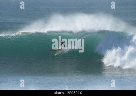 Surfer equitazione Bells spiaggia, grandi onde inviare spray sopra le onde turchesi vicino a Torquay Australia - la casa di surf professionale Foto Stock