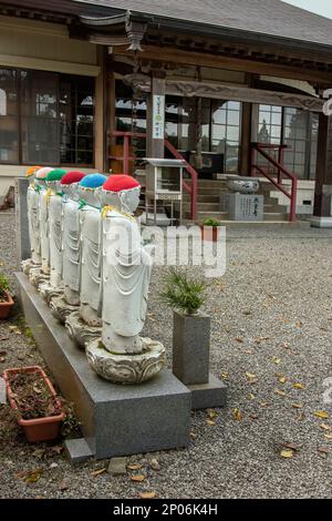 Statue di Gizoo, discepoli di Buddha, al tempio di Jingui indossando cappelli e pettinini a maglia (kasa), Kamiyama, Giappone Foto Stock