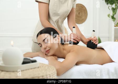 Giovane donna ricevente sacchetto di erbe massaggio nella spa salone Foto Stock